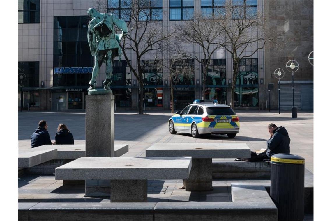 Behörden loben: Viele halten sich an Corona-Auflagen Momentaufnahme vom alten Markt in Dortmund: Die Polizei mit einem Streifenwagen in Einsatzl. Foto: Bernd Thissen/dpa