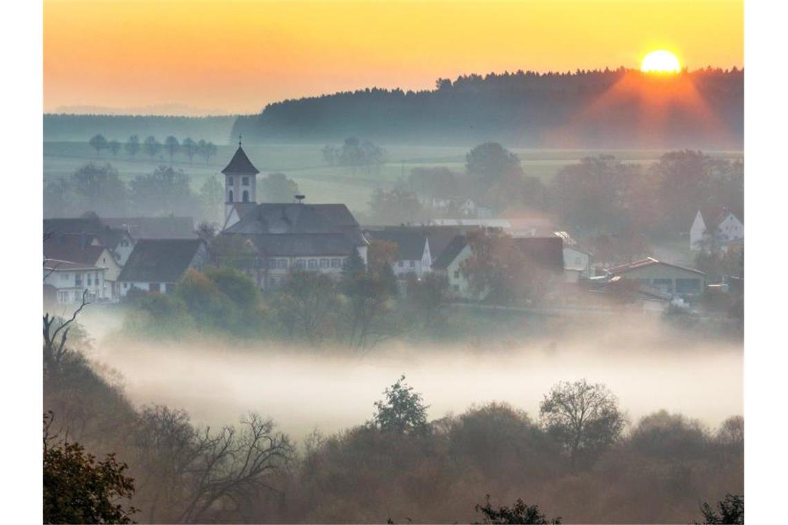 Morgennebel über einer Ortschaft. Foto: Thomas Warnack/dpa