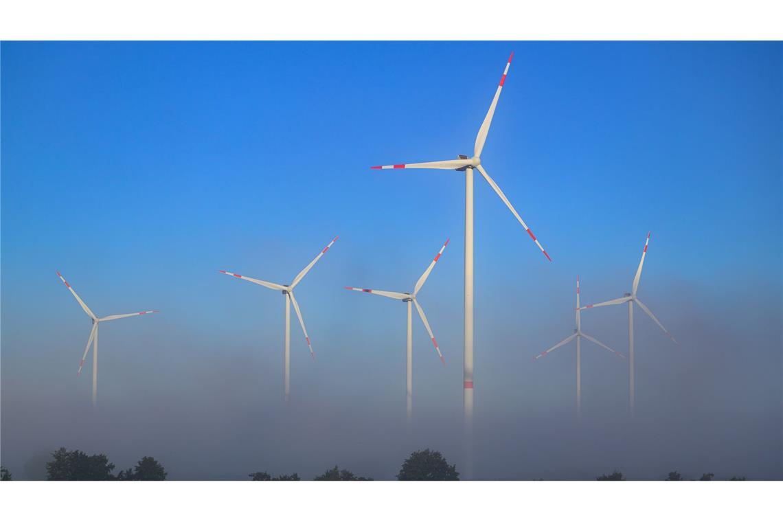 Morgens ragen Windenergieanlagen bei Jacobsdorf aus dem Nebel.