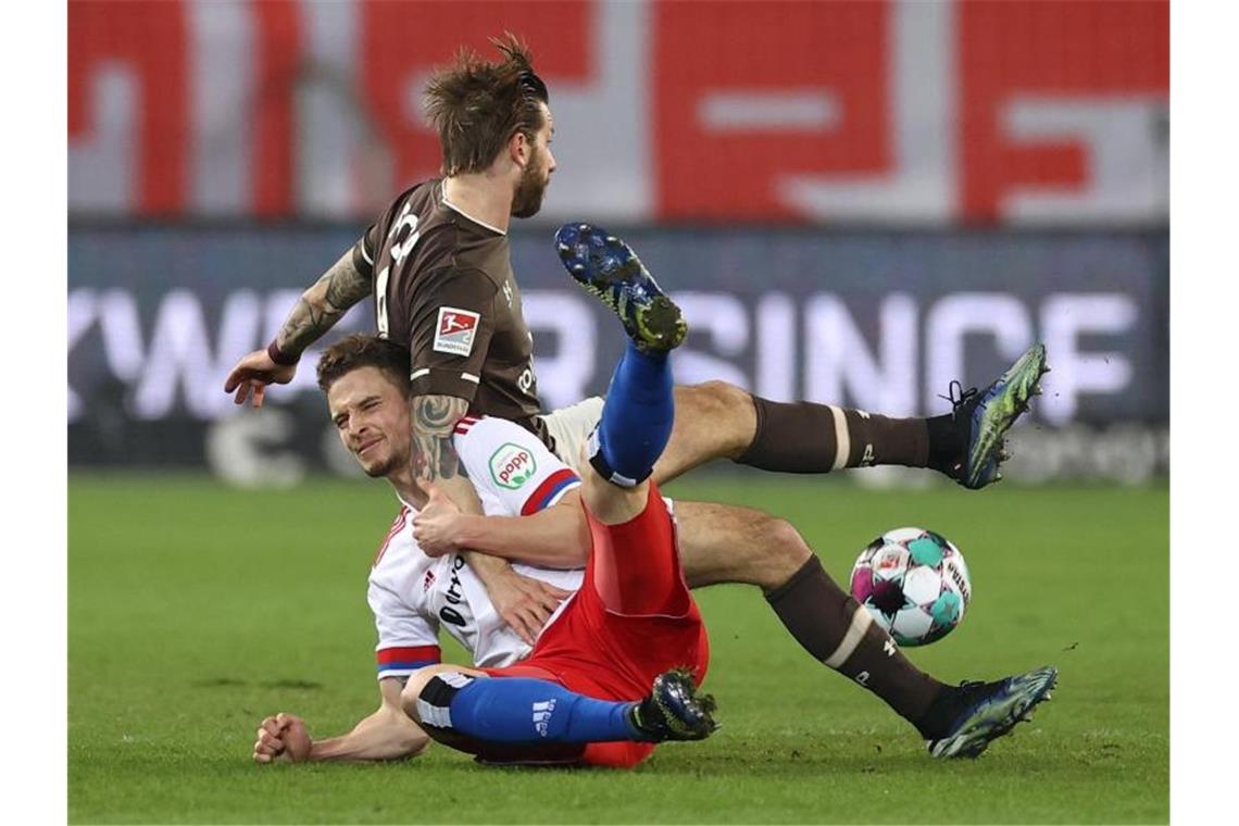 Pleite beim FC St. Pauli: HSV nur noch Tabellenvierter Moritz Heyer (l) vom HSV und Guido Burgstaller vom FC St. Pauli kämpfen um den Ball. Foto: Christian Charisius/dpa-Pool/dpa