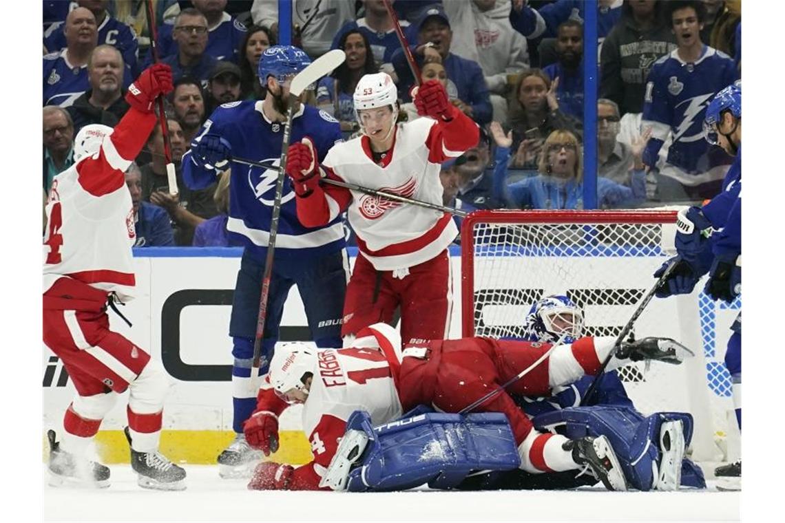 NHL: Seider punktet bei Red-Wings-Niederlage Moritz Seider (M.) scorte zwar, aber verlor mit den Detroit Red Wings. Foto: Chris O'meara/AP/dpa