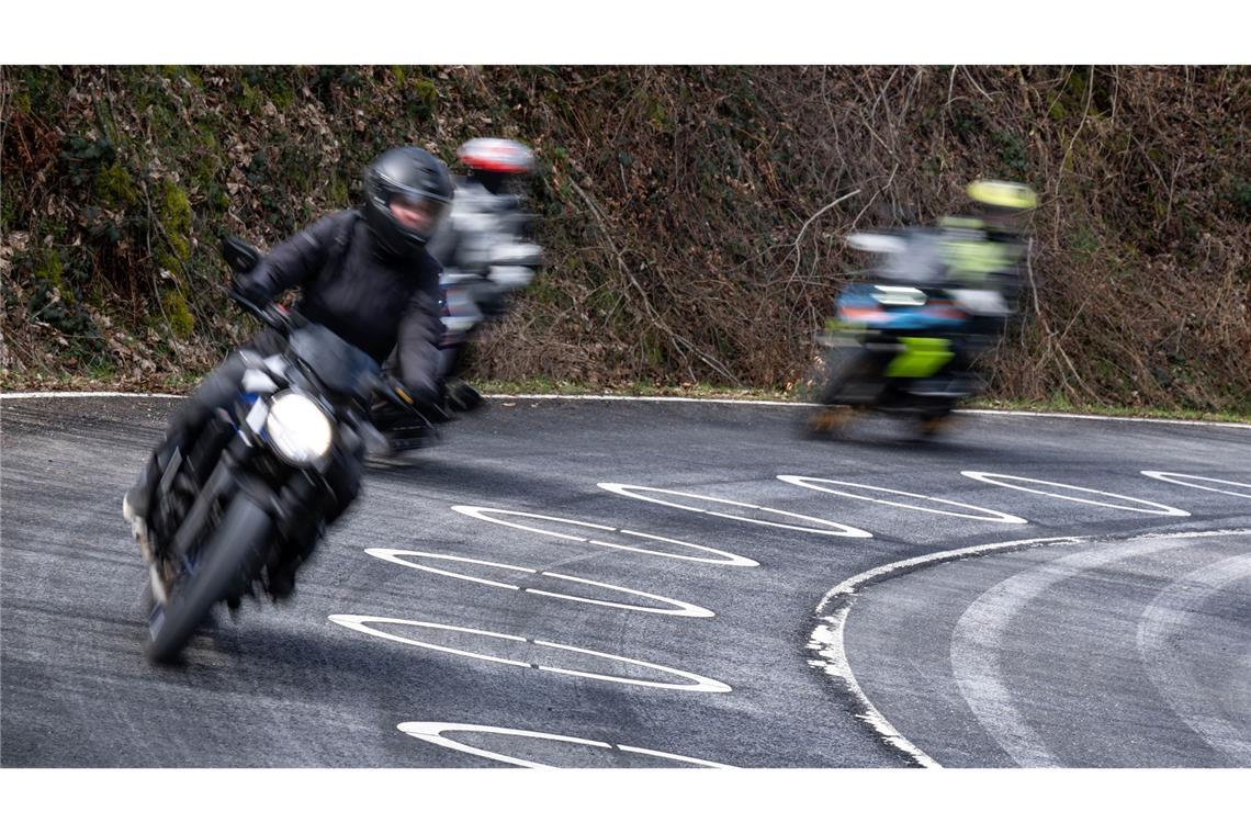 Motorradfahrer durchfahren die mit Ellipsen markierte Kurve des Verkehrsversuches bei der Eröffnung der Motorradsaison.