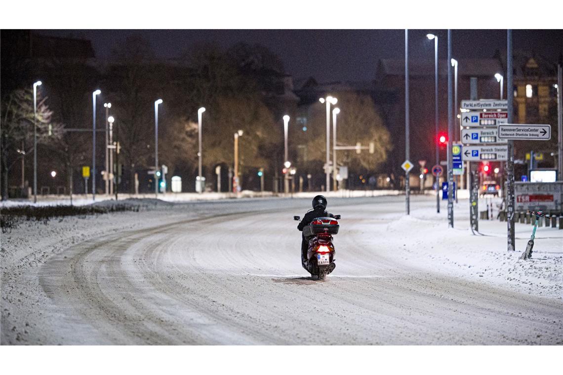 Motorroller kämpft sich am frühen Morgen durch Schnee im Stadtzentrum in Hannover