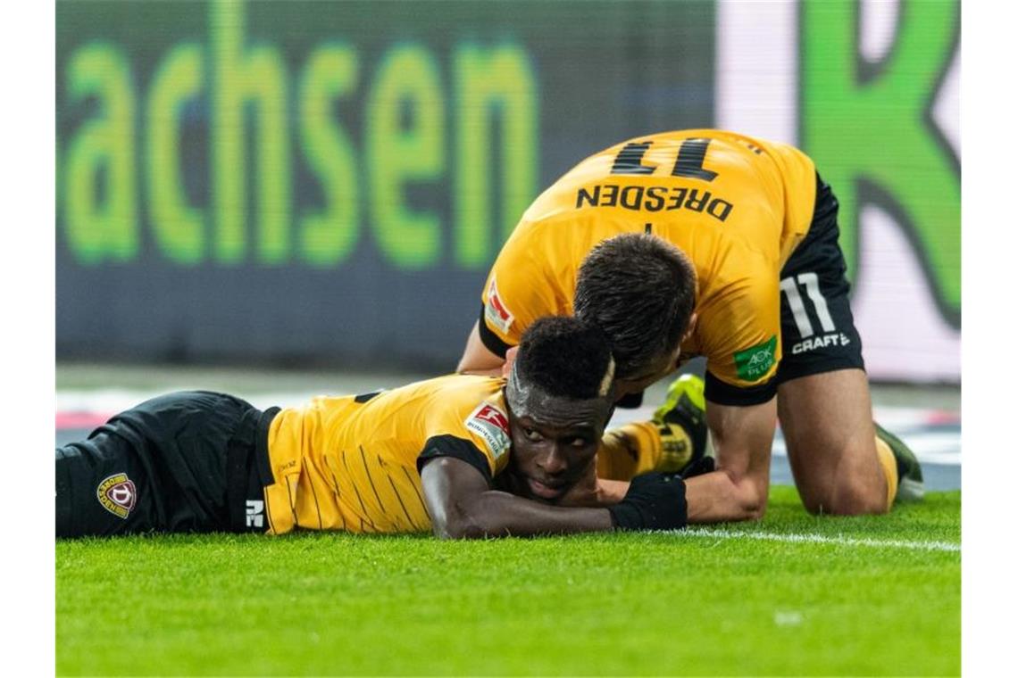 Moussa Kone (l) feiert mit Dynamo-Torschütze Alexander Jeremejeff. Foto: Robert Michael/dpa-Zentralbild/dpa