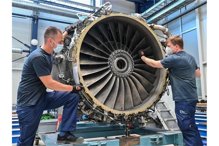 MTU-Mitarbeiter werkeln an einem Triebwerk vom Typ CF-34. Foto: Patrick Pleul/dpa