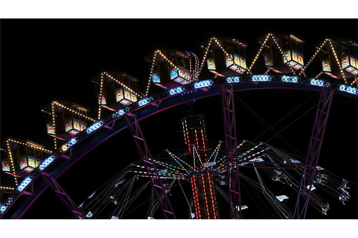 München: Wiesn-Glanz bei Nacht – Das Riesenrad leuchtet vor dem Tower auf der Theresienwiese