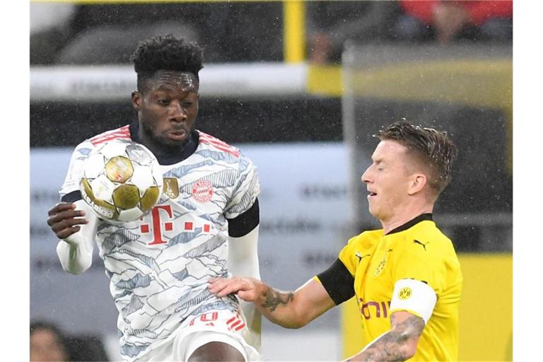 Münchens Abwehrspieler Chris Richards (l) und Dortmunds Mittelfeldspieler Marco Reus. Foto: Bernd Thissen/dpa