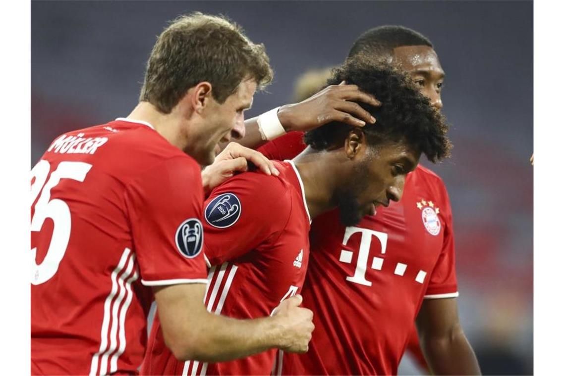 Münchens Matchwinner Kingsley Coman (M) bejubelt sein 4:0 zusammen mit Thomas Müller (l) und David Alaba. Foto: Matthias Schrader/Pool AP/dpa