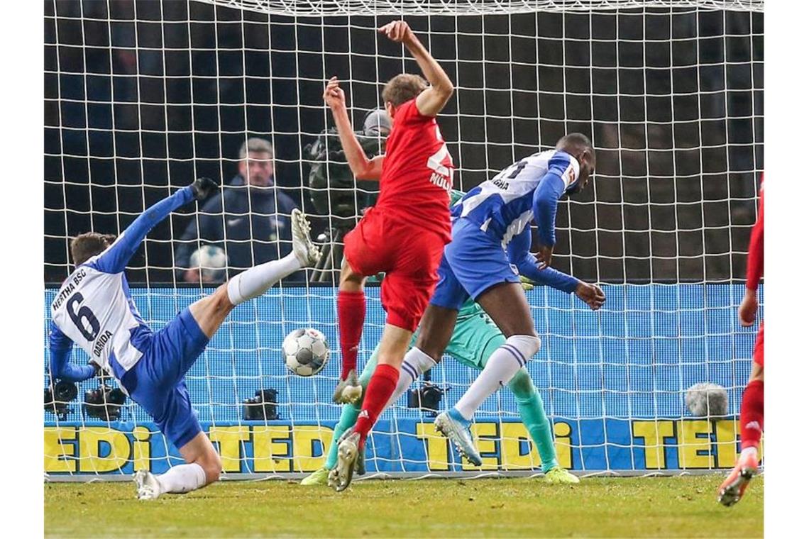 Münchens Thomas Müller (2.v.l) trifft zum 1:0. Berlins Darida (l) und Torwart Jarstein kommen nicht mehr an den Ball. Foto: Andreas Gora/dpa