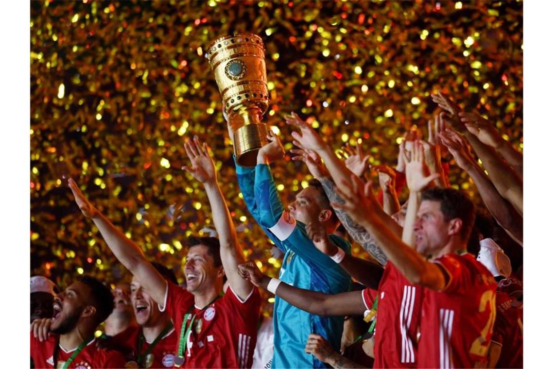 Münchens Torhüter Manuel Neuer hält die Trophäe jubelt mit dem DFB-Pokal. Foto: Annegret Hilse/Reuters/POOL/dpa