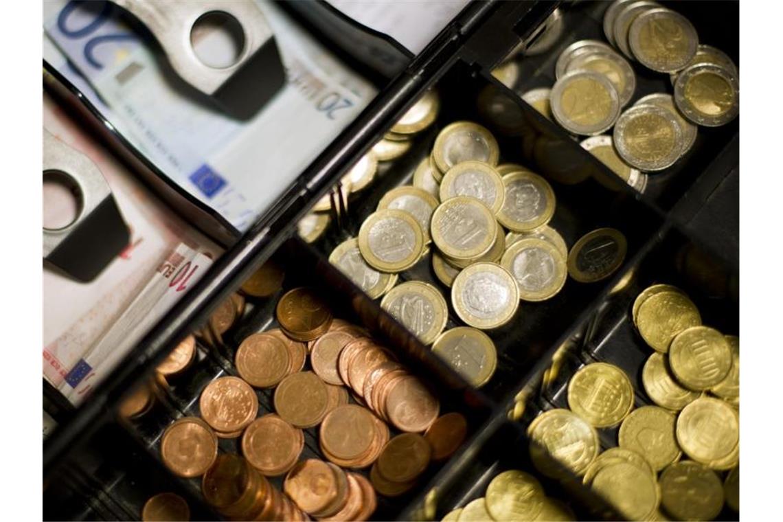 Münzen und Geldscheine liegen in einer Kasse. Foto: picture alliance/dpa/Symbolbild