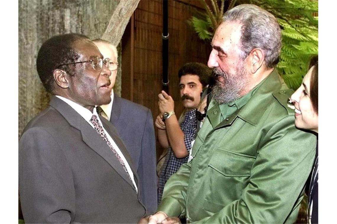 Simbabwes Ex-Präsident Robert Mugabe gestorben Mugabe wird 2002 vom kubanischen Staatschef Fidel Castro in Havanna begrüßt. Foto: Jose Goitia/Pool/epa