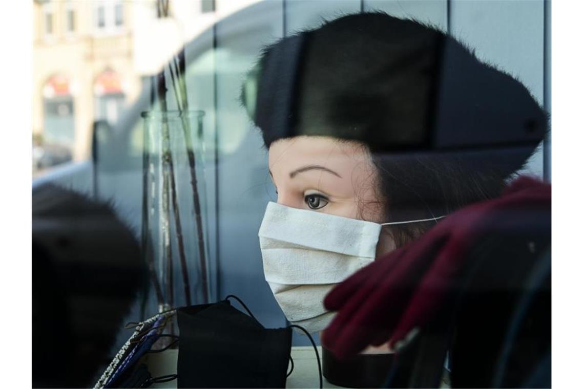 Mundschutz-Dekoration in einem Geschäft in Kassel. Viele Einzelhändler bereiten sich auf eine Wiedereröffnung ihrer Läden vor. Foto: Uwe Zucchi/dpa