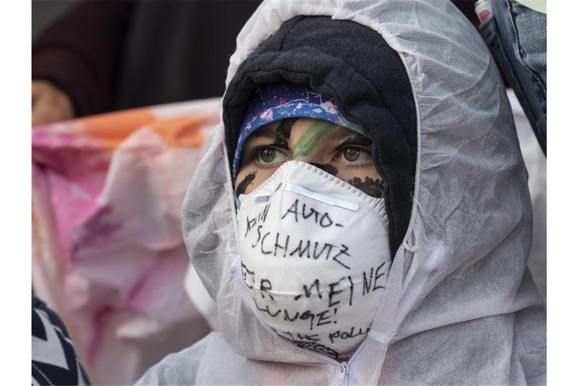 Mundschutz und Schutzkleidung sollen wohl die Umweltverschmutzung durch Autos symbolisieren. Foto: Boris Roessler