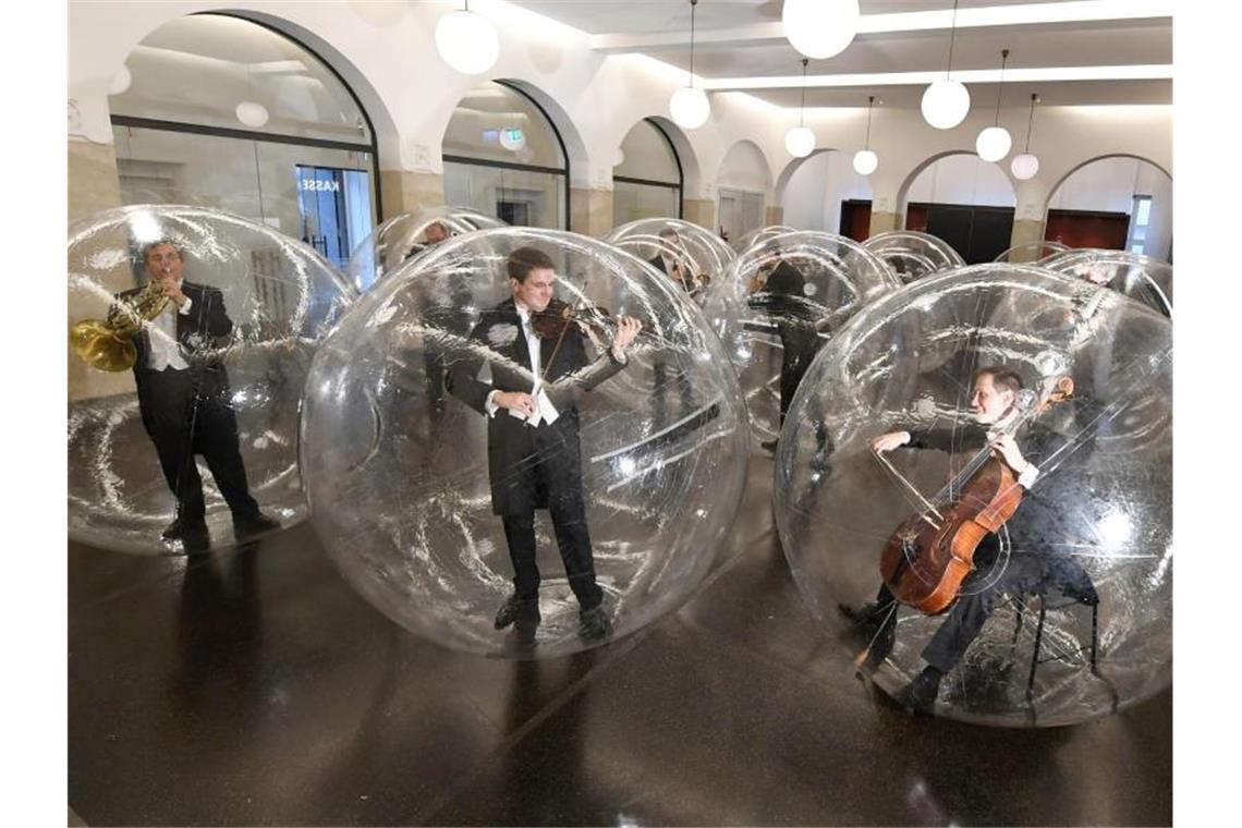 Kunstaktion: Musiker spielen in transparenten Bällen Musiker der Stuttgarter Philharmoniker spielen während der Kunstaktion „Social Distance Stacks“. Foto: Franziska Kraufmann/dpa