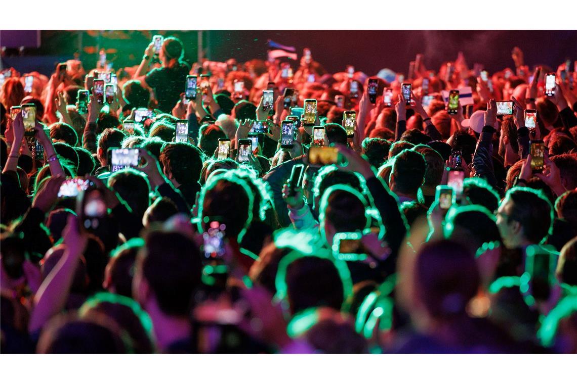 Musikfans feiern im Eurovision Village in Wien vor dem Historischen Rathaus bei einem Konzert.