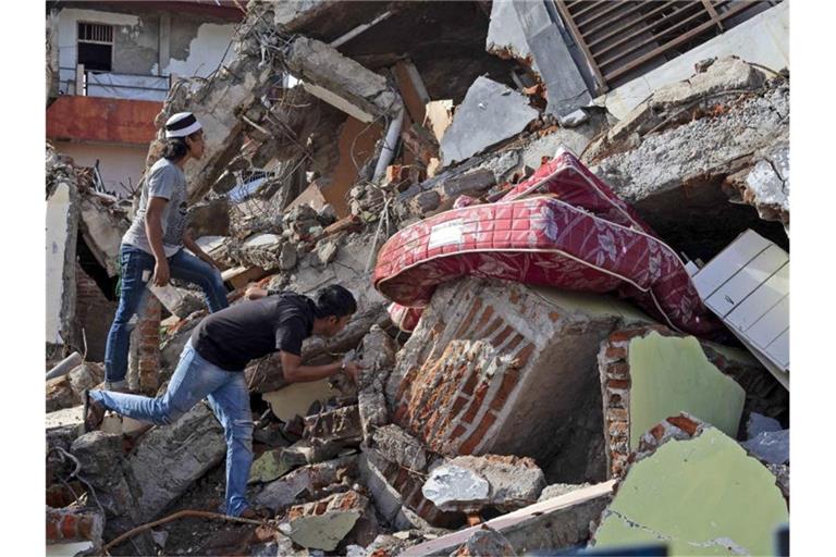 Nach dem Erdbeben auf der indonesischen Insel Sulawesi fahnden Anwohner noch immer nach Lebenszeichen. Foto: Yusuf Wahil/AP/dpa