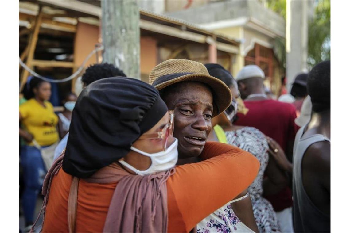 Nach dem Erdbeben der Stärke 7,2 in Haiti weinen Angehörige während der Suche nach Vermissten. Die Zahl der Todesopfer ist inzwischen auf über 1200 gestiegen. Foto: Joseph Odelyn/AP/dpa