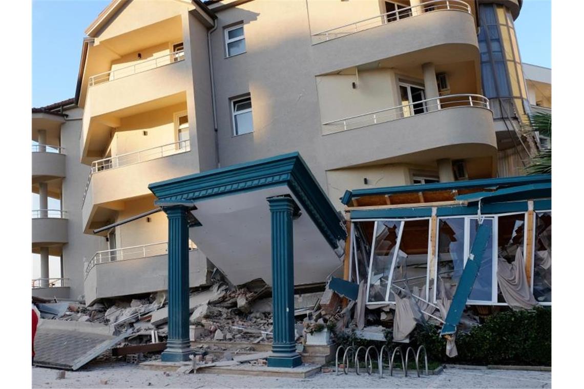 Nach dem Erdbeben stehen zwei Männer neben einem beschädigten Gebäude in Durres. Foto: Hektor Pustina/AP/dpa