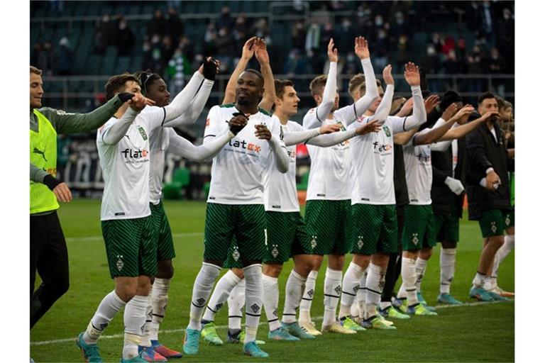 Nach dem Heimsieg gegen den FC Augsburg können die Gladbacher Spieler befreit mit den Fans feiern. Foto: Federico Gambarini/dpa
