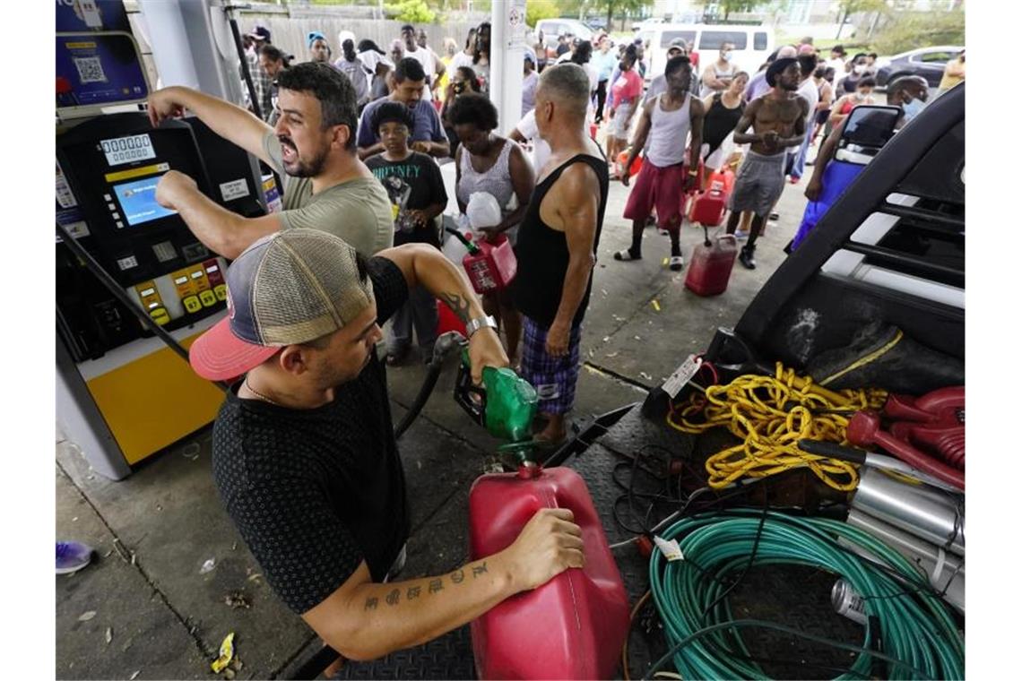 Nach dem Hurrikan Ida stehen die Menschen in New Orleans Schlange, um Benzin in Kanister zu füllen. Foto: Eric Gay/AP/dpa