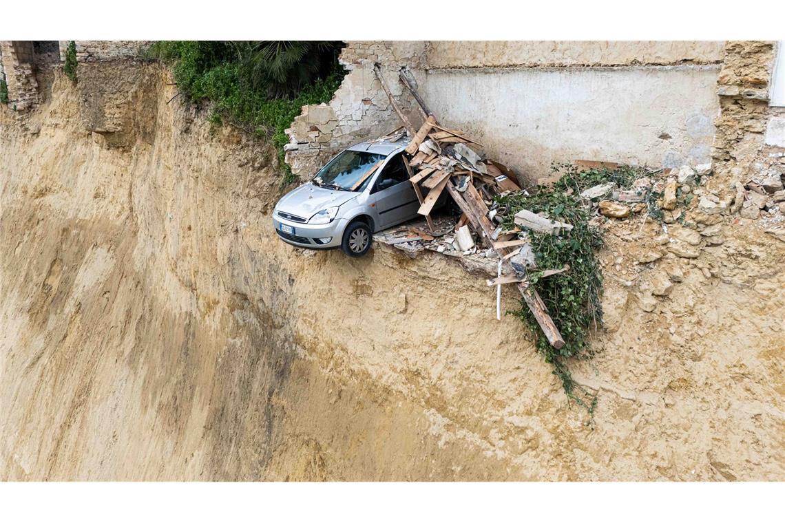 Nach dem schweren Erdrutsch auf Sizilien hängt ein Auto über einem Abgrund.