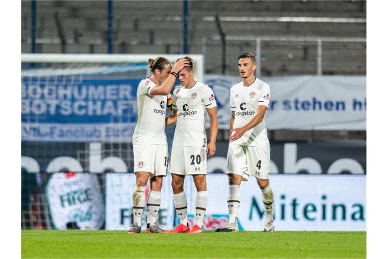 Nach dem Spielende können sich Paulis Spieler über den Punktgewinn freuen. Foto: Marcel Kusch/dpa