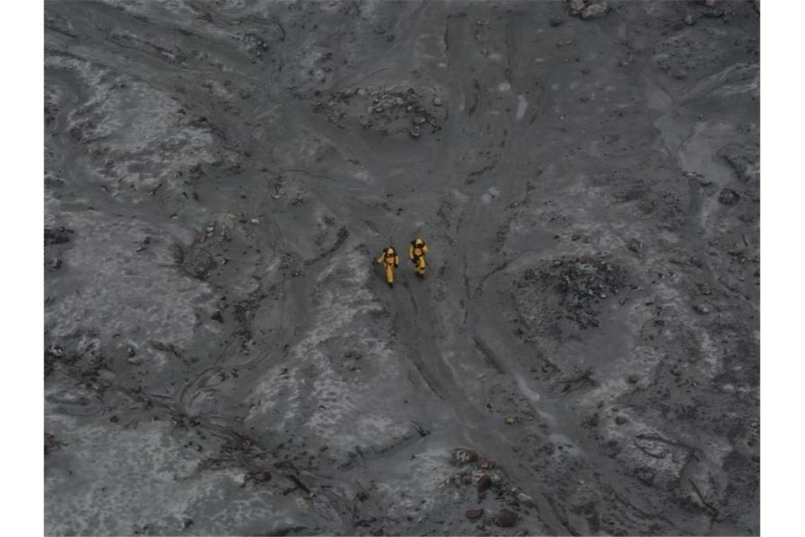 Nach dem Ausbruch: zwei Einsatzkräfte auf White Island. Foto: -/New Zealand Defence Force/dpa