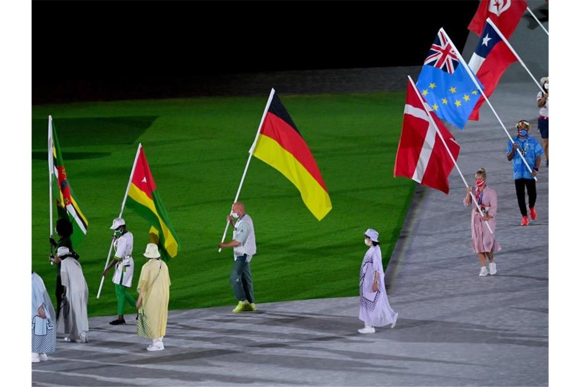 Nach der Abschlussfeier geht es für die Athleten heim: Fahnenträger Ronald Rauhe (M) trägt die deutsche Fahne. Foto: Marijan Murat/dpa