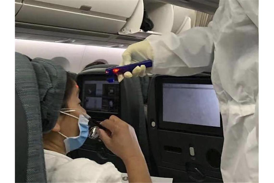 Immer mehr Infektionen: Berlin warnt vor Reisen nach China Nach der Landung auf dem Flughafen in Rom, wird in einem Flugzeug aus Hongkong die Temperatur der Passagiere gemessen. Foto: Erika Kinetz/AP/dpa