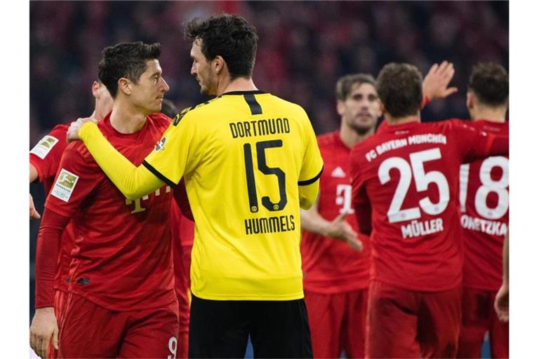 Nach der Niederlage wechselt BVB-Ersatzkapitän Mats Hummels (15) einige Worte mit Bayern-Torjäger Robert Lewandowski (r). Foto: Matthias Balk/dpa