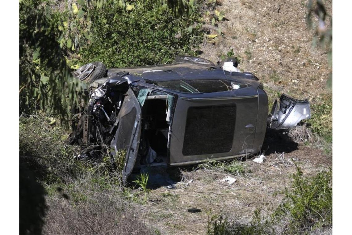 Nach einem heftigen Unfall von Golf-Profi Tiger Woods liegt das zerstörte Auto auf der Seite im Graben. Foto: Ringo H.W. Chiu/AP/dpa