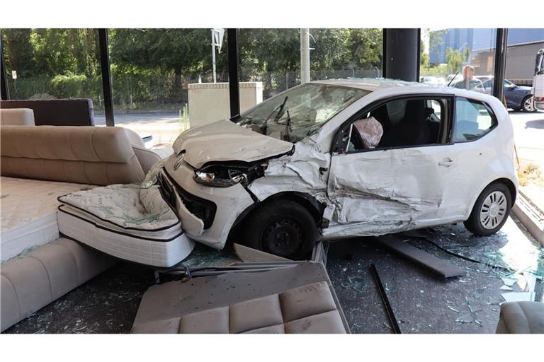 Nach einem Unfall steht ein Kleinwagen in einem Möbelgeschäft.