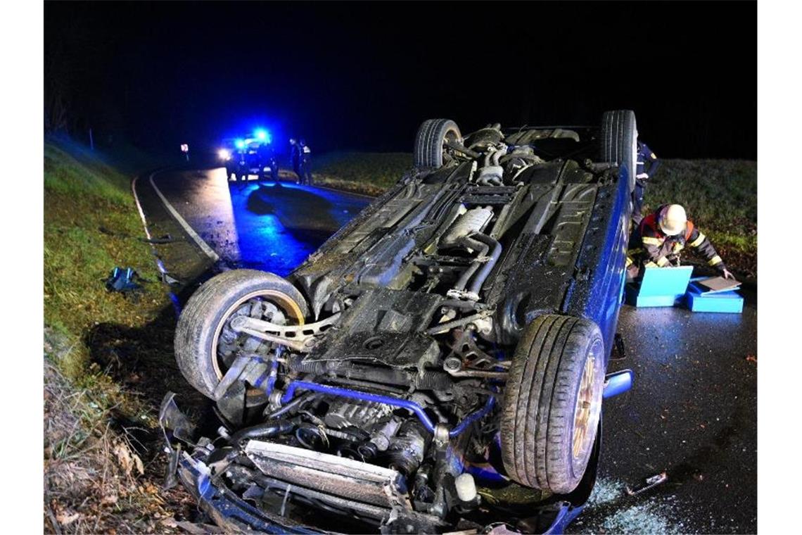 Nach einem Verkehrsunfall liegt ein Fahrzeug auf dem Dach auf der Straße. Foto: René Priebe/dpa/Aktuell