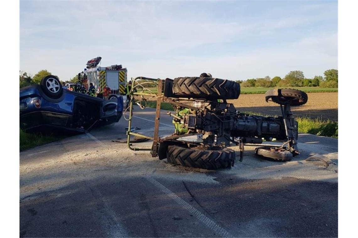Auto rammt Traktor und überschlägt sich: Zwei Verletzte Nach einem Zusammenstoß liegt ein Traktor auf der Seite (r) und ein Auto auf dem Dach. Foto: Marco Dürr/Einsatz-Report 24/dpa