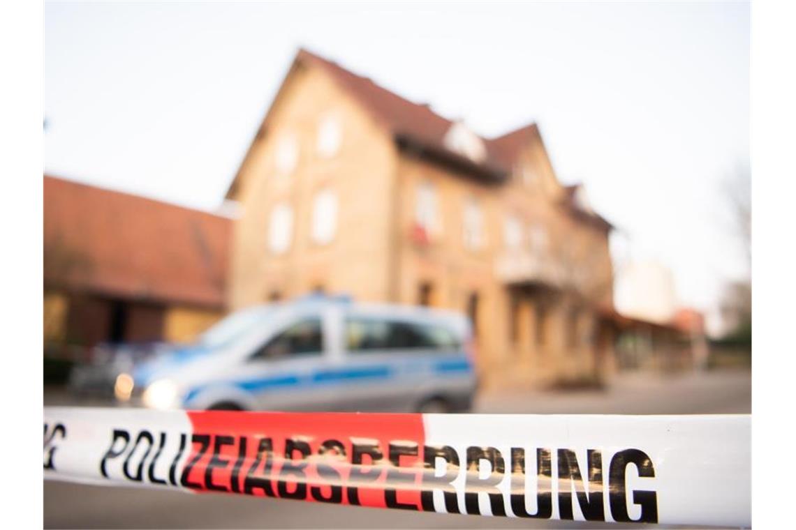 Nach Schüssen in Rot am See steht ein Polizeiauto hinter einer Absperrung. Foto: Tom Weller/dpa/Archivbild