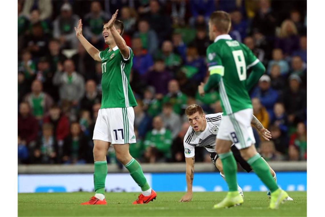 Halstenberg bringt DFB-Team auf EM-Kurs Nach seinem Foul an Toni Kroos (M) gibt sich der Nordire Paddy McNair (l) unschuldig. Foto: Christian Charisius
