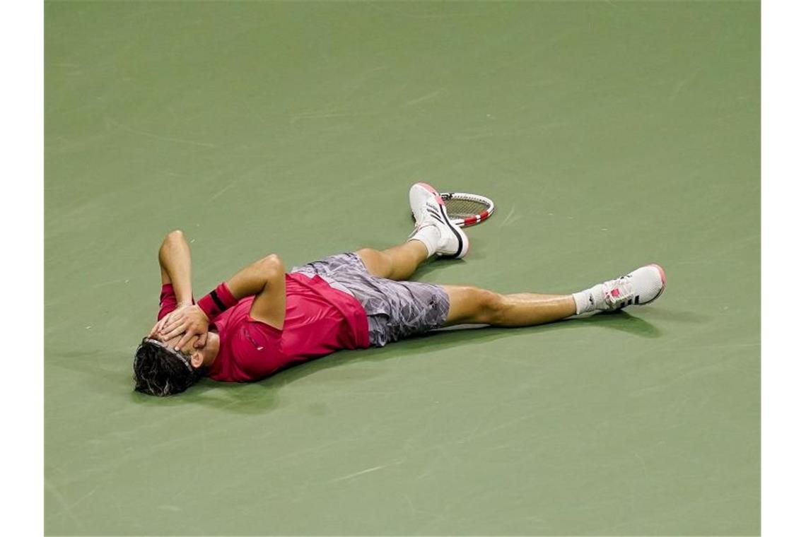 Nach seinem Sieg lässt sich Dominic Thiem rücklings auf den Boden fallen. Foto: Seth Wenig/AP/dpa