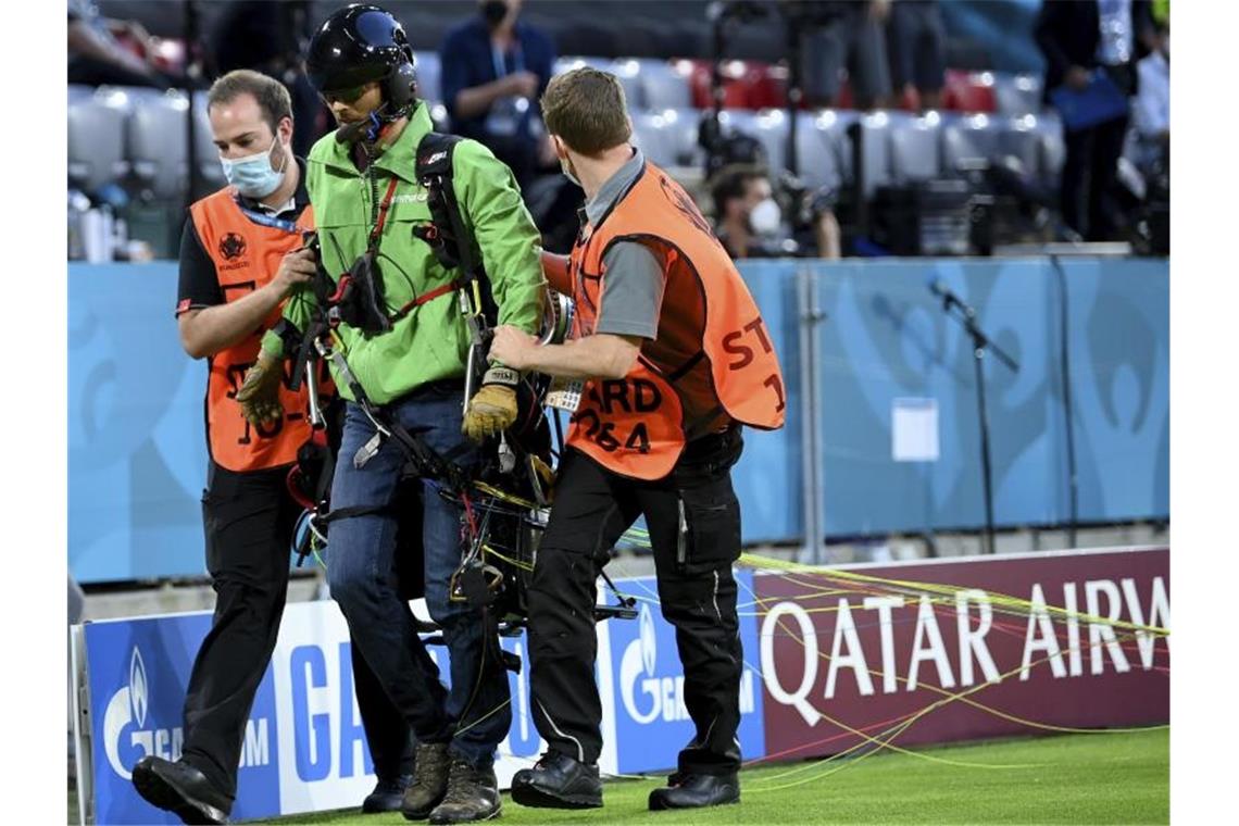 Nach seiner waghalsigen Aktion wird der Aktivist von Greenpeace vom Spielfeld geführt. Foto: Matthias Hangst/Getty Pool/dpa