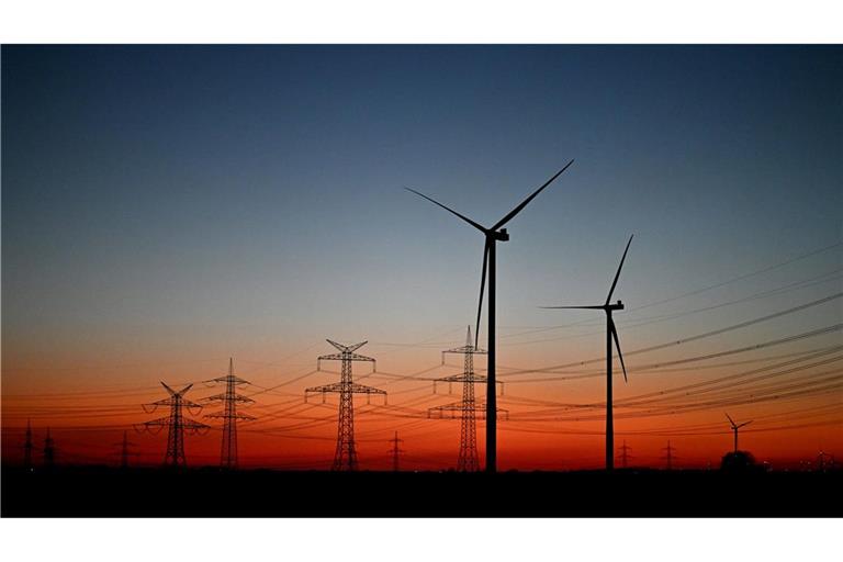 Nach Sonnenuntergang stehen Windräder auf einem Feld bei Pulheim.
