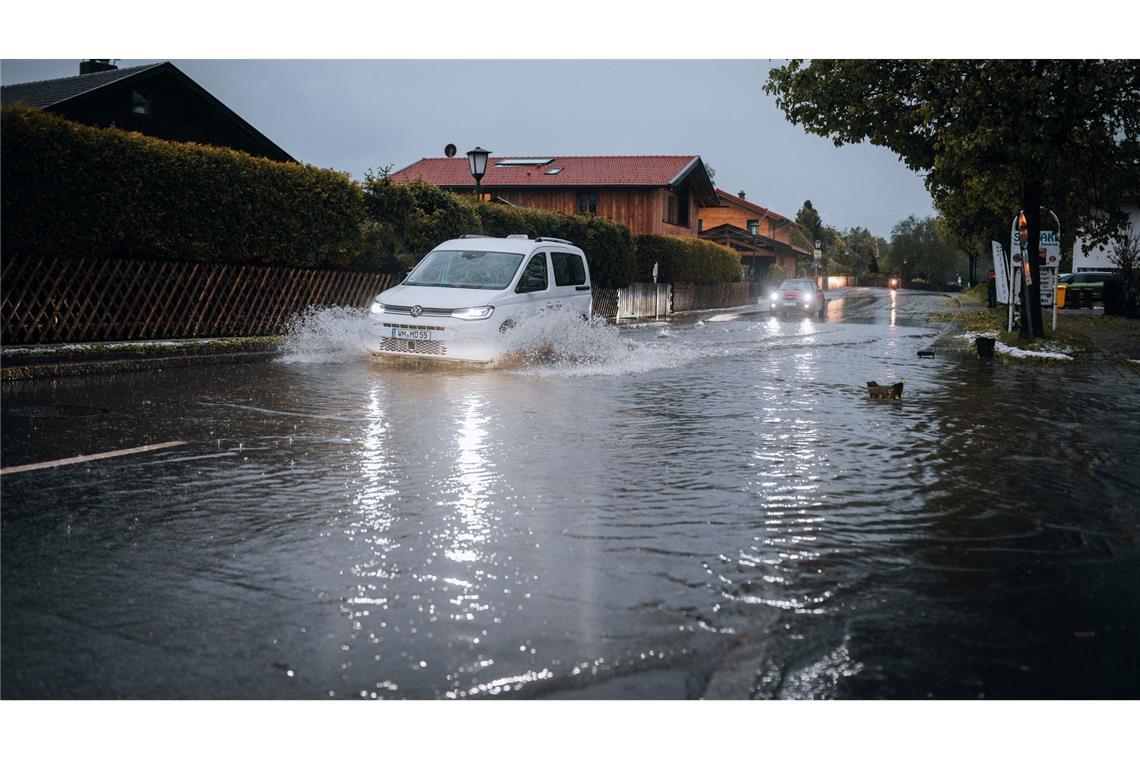 Bilder des Tages Nach starkem Regen fahren Autos durch Wasser auf einer teils überschwemmten Straße im bayerischen Wallgau.