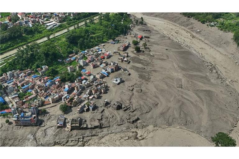 Nach Sturzfluten im nepalesischen Distrikt Nuwakot stehen beschädigte Häuser gefährlich nahe an den angeschwollenen, mit Treibgut verstopften Ufern des Trishuli-Flusses. Eine massive Sturzflut in Nepal hat nach Behördenangeben einigen Menschen das Leben gekostet.