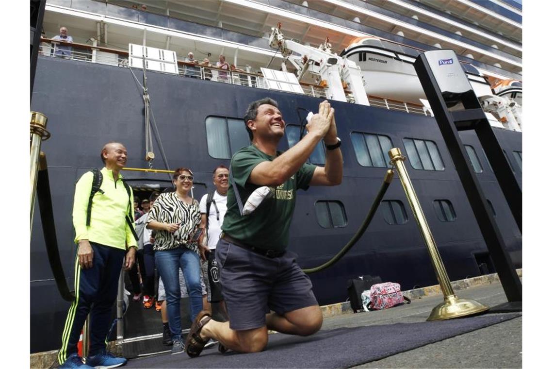 Nachdem sie das Kreuzfahrtschiff „Westerdam“ im Hafen von Sihanoukville verlassen, zeigen sich einige Passagiere sichtbar erleichtert. Foto: Heng Sinith/AP/dpa