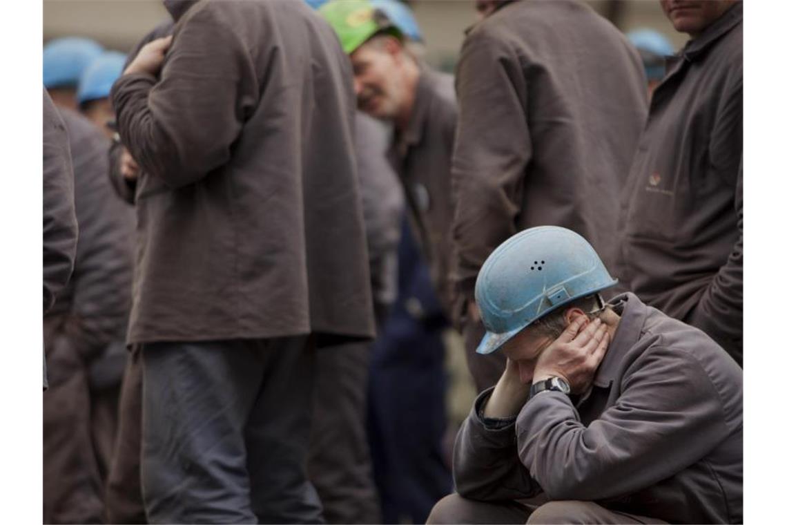 Wirtschaftsforscher: Abschwung endet am Jahresende Nachdenklich: Arbeiter auf einem Werftgelände zwischen seinen Kollegen. Der Deutsche Industrie- und Handelskammertag sieht die Konjunktur auf Talfahrt. Foto: Arno Burgi/dpa-Zentralbild/dpa