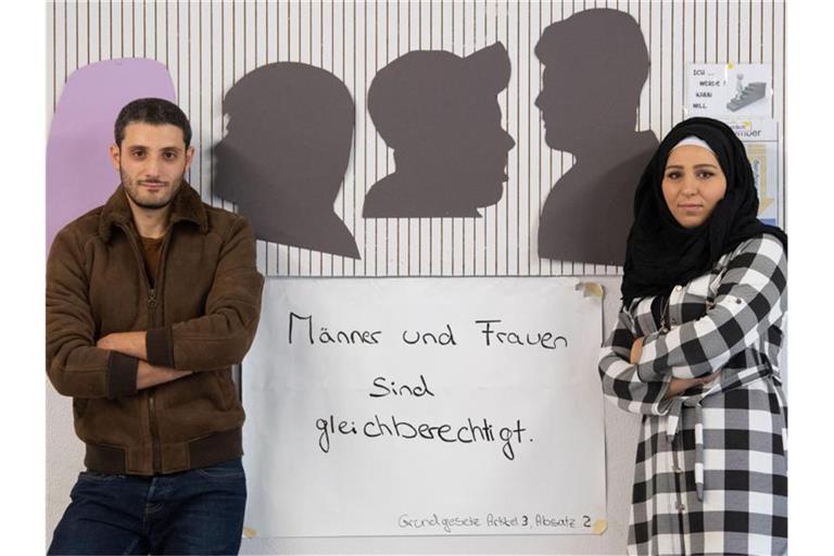 Nadin Almesre und Moaaz Bunduk, Mentoren von „Love Needs Respect“, stehen in einem Klassenzimmer. Foto: Marijan Murat/dpa
