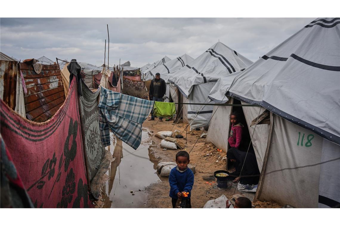 Nanaa Abu Jari kocht in Nuseirat im zentralen Gazastreifen vor ihrem Zelt, das von Regenwasser überflutet wurde..