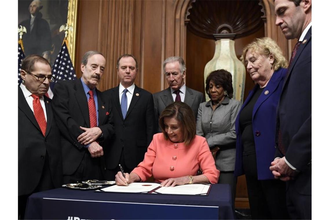 Nancy Pelosi, Vorsitzende des Repräsentantenhauses, unterzeichnet eine Resolution zur Übermittlung der Anklage im Amtsenthebungsverfahren gegen US-Präsident Trump an den Senat. Foto: Susan Walsh/AP/dpa