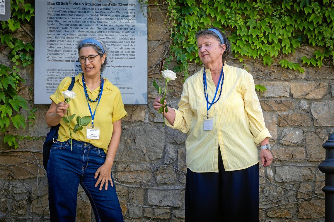 Nataša Hufen (links) und Nicole Huber führen die Teilnehmer der dystopischen Stadtführung „Sprachlos durch Backnang 2033“ auch zu den Stolpersteinen am Ölberg. Am Ende der Tour verlassen sie ihre Rollen und legen zum Gedenken eine weiße Rose nieder. Foto: Alexander Becher