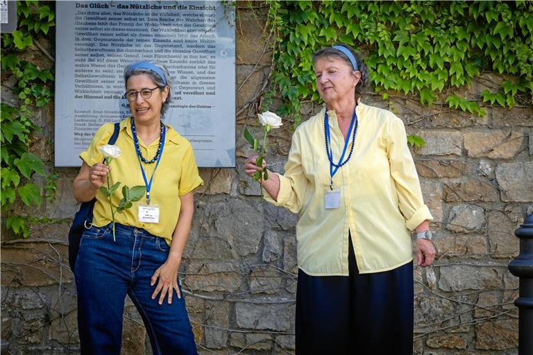 Nataša Hufen (links) und Nicole Huber führen die Teilnehmer der dystopischen Stadtführung „Sprachlos durch Backnang 2033“ auch zu den Stolpersteinen am Ölberg. Am Ende der Tour verlassen sie ihre Rollen und legen zum Gedenken eine weiße Rose nieder. Foto: Alexander Becher