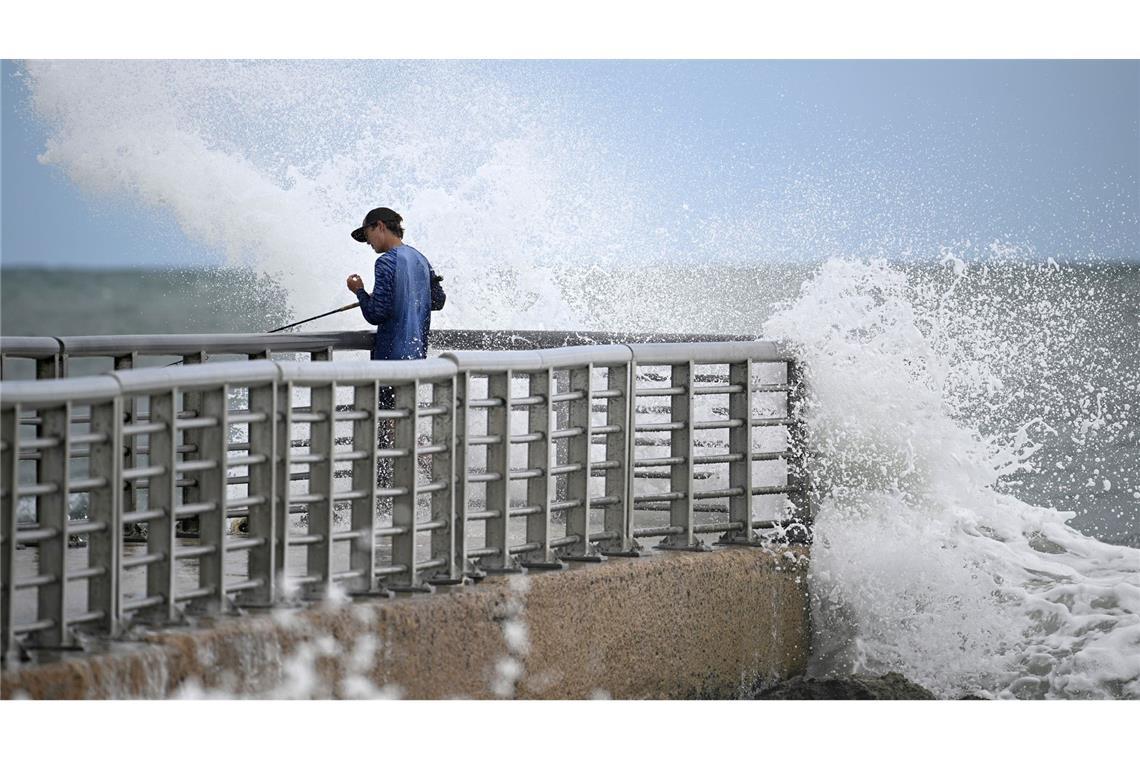 Nathan Goff wird beim Angeln auf dem Steg im Sebastian Inlet State Park von einer Welle durchnässt, als der Tropensturm Imelda in Melbourne Beach, Florida, an der Küste vorbeizieht.